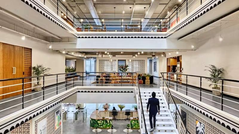A multi-storey office atrium with open galleries and a central staircase