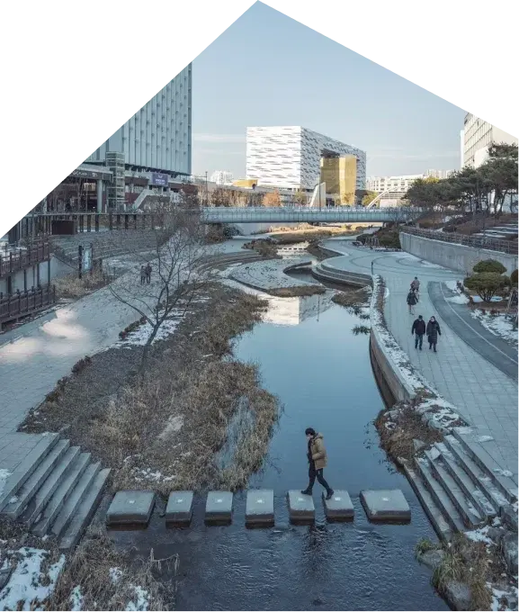 A walkway beside a stepped water channel between office buildings